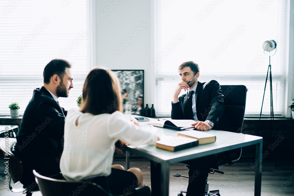 Concentrated coworkers brainstorming in office room Concentrated coworkers brainstorming in office room