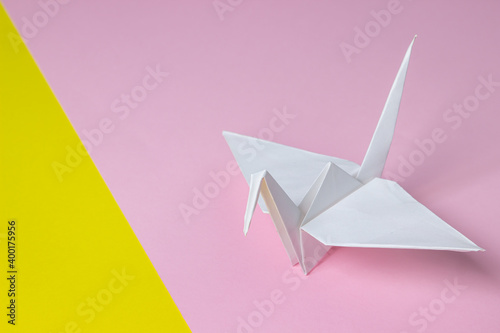Paper crane on a geometric background. Colored background. Background for design, lettering or logo.