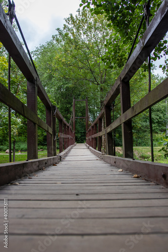Fototapeta Naklejka Na Ścianę i Meble -  old wooden suspension bridge. bridge over the forest river