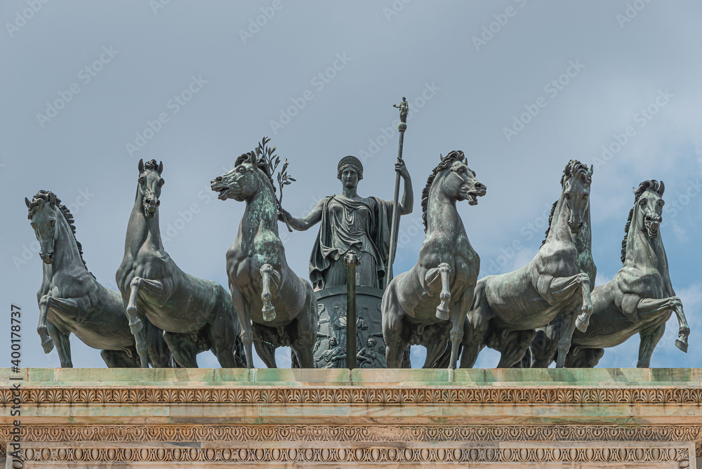 Obraz premium Statues of 6 horses and Goddess Victoria at the top of Triumphal Arch called Arch of Peace (Porta Sempione) in Milan historical downtown, Sempione Park, Italy.