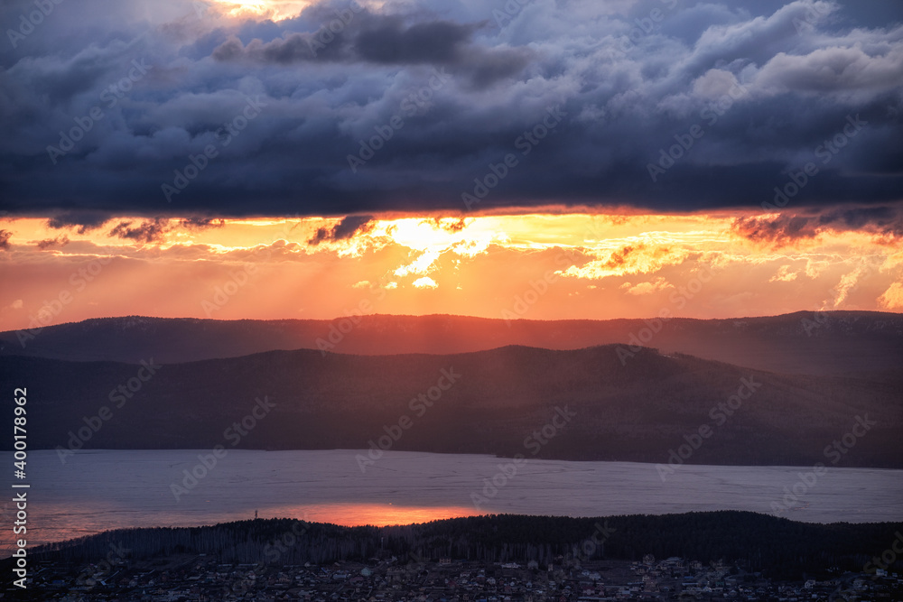 Obraz premium Sunset on the background of an icy lake and mountains