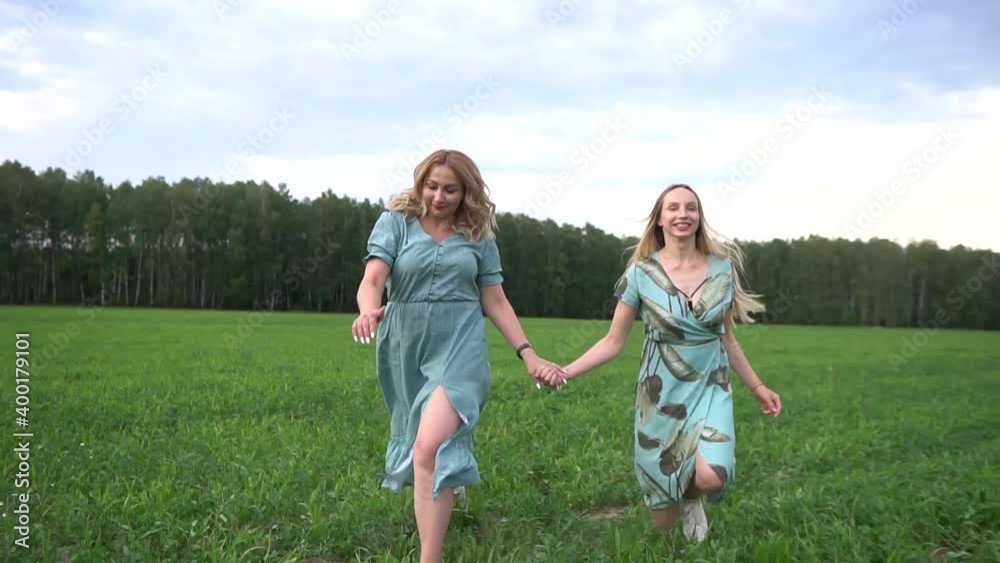 best friends. Friends hold hands. Two friends walking in nature. Love. two sisters spend time together best friends. Friends hold hands. Two friends walking in nature. Love. two sisters spend time together