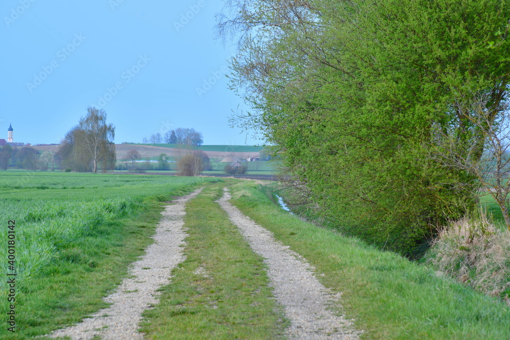 Feldweg auf dem Land neben einem Bach