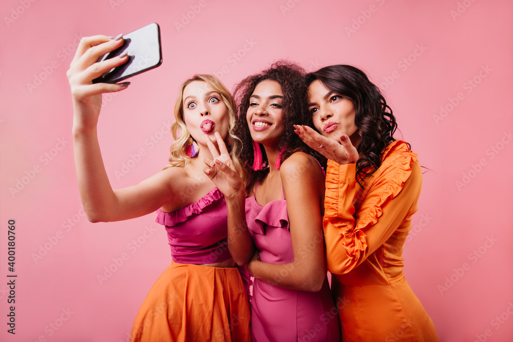 Latin happy girl sending air kiss. Charming ladies making selfie on pink background. Latin happy girl sending air kiss. Charming ladies making selfie on pink background.