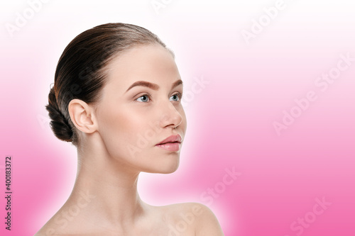 Portrait of young attractive girl with perfect smooth skin on a pink background with a shaded white outline