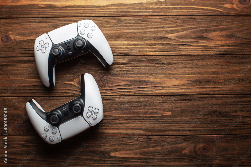Two dualsense ps5 controllers on wooden background, gaming concept Stock  Photo | Adobe Stock