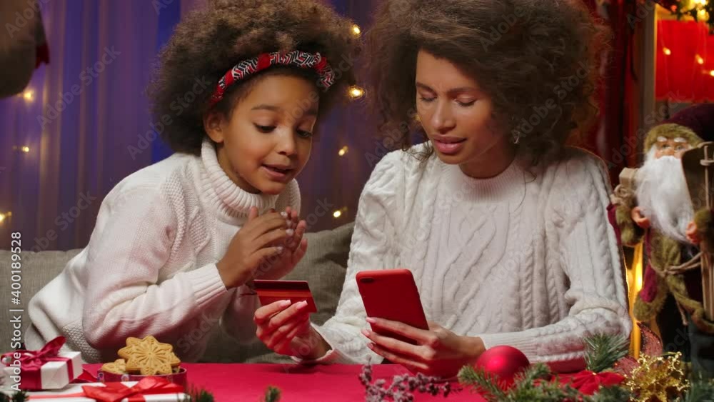 African american woman making online purchase on the internet using credit card and smartphone. Happy family portrait, New Years celebration concept. Close up. African american woman making online purchase on the internet using credit card and smartphone. Happy family portrait, New Years celebration concept. Close up.