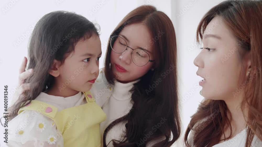 Lovely family couple lesbian comforting an adopted daughter cry due to them and tell something to feel better.