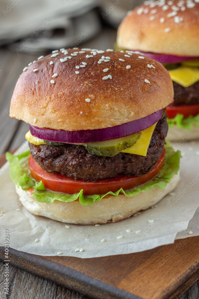 Burgers with meat, tomato, cucumber, cheese and onion. American cuisine. Fast food. Burgers with meat, tomato, cucumber, cheese and onion. American cuisine. Fast food.