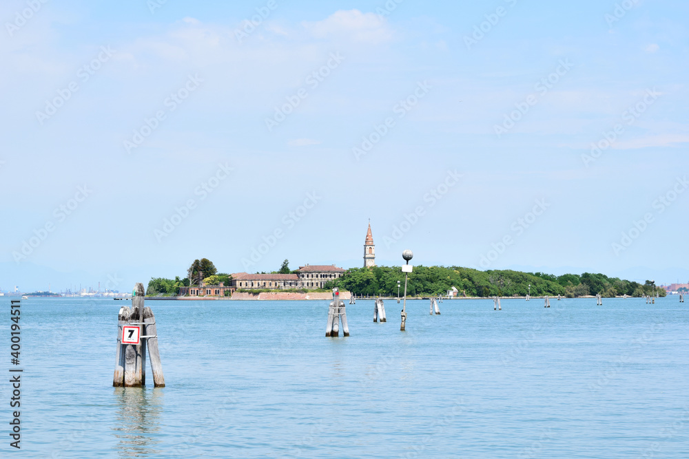 Poveglia, a small island located between Venice and Lido in the Venetian Lagoon, Italy, as seen from Malamocco on Lido Island. It was used as a quarantine station in history.
