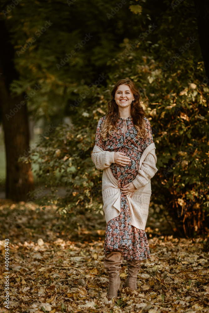 Lovely pregnant woman enjoying autumn in the park