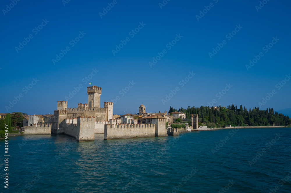Aerial view on Sirmione sul Garda. Italy, Lombardy. View by Drone. Rocca Scaligera Castle in Sirmione. Amazing view to the old bridge and harbor of Sirmione