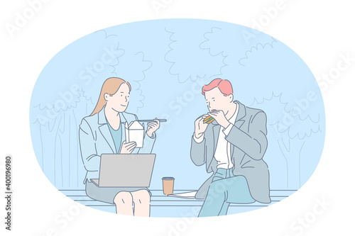 Street food, Unhealthy eating, calories concept. Young business couple office workers sitting and eating burger and noodles in park during lunch break. Overweight, snack, lifestyle, harmful eating