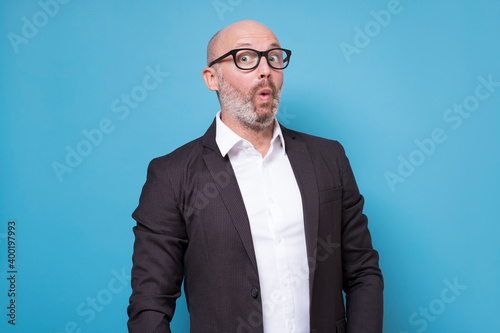 Tableau sur toile Mature hispanic man in suit with surprised face expression