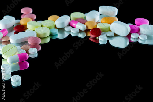 Lot of pharmaceutical pills medicine from above in black background