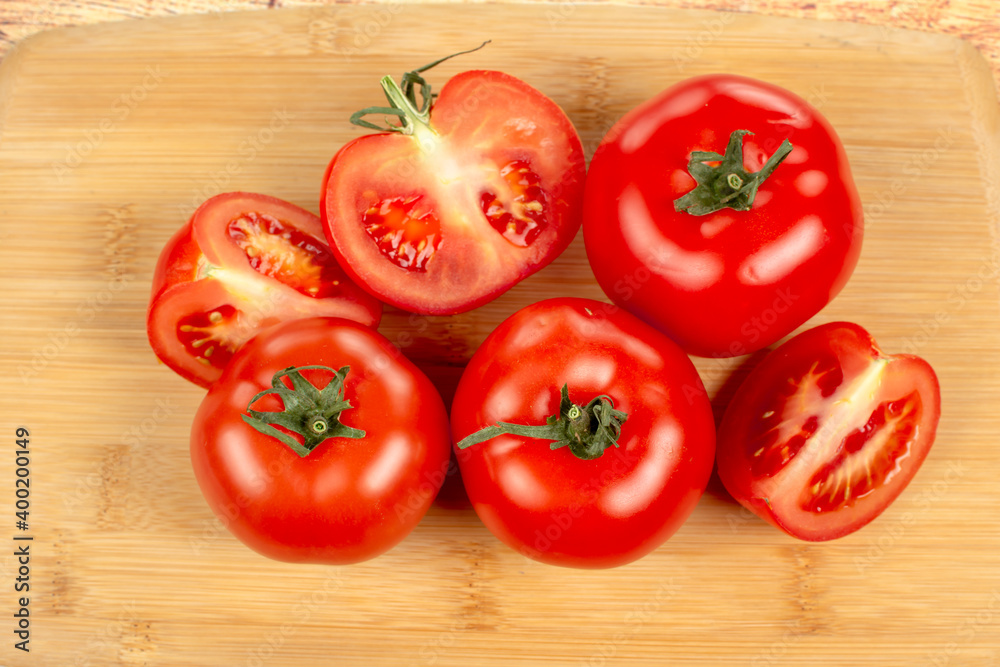 red tomatoes and tomato slices on a wooden board red tomatoes and tomato slices on a wooden board