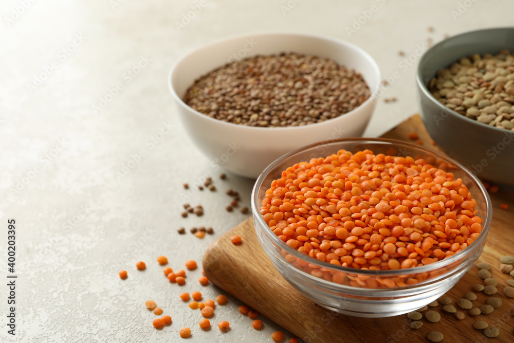 Board with bowls with legumes on white textured background Board with bowls with legumes on white textured background