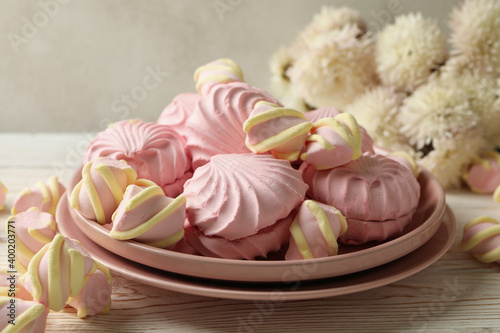 Plate with sweet marshmallow on wooden background