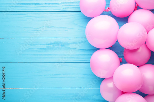 Pink balloons on blue wooden background. Birthday, holiday concept.