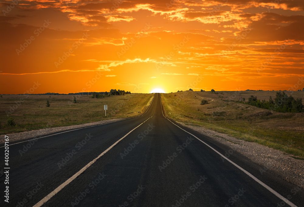 Sunrise on the horizon over an empty highway Sunrise on the horizon over an empty highway