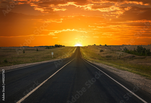 Sunrise on the horizon over an empty highway