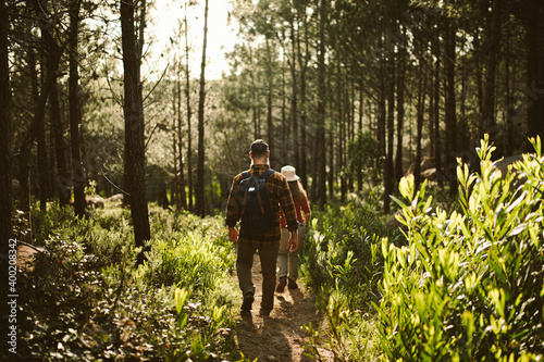 Couple hiking through the woods on sunny day together 