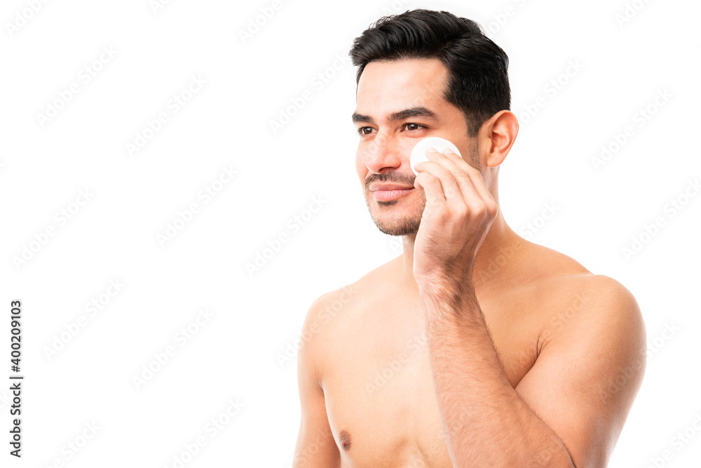 Man cleaning his face with a facial sponge Man cleaning his face with a facial sponge