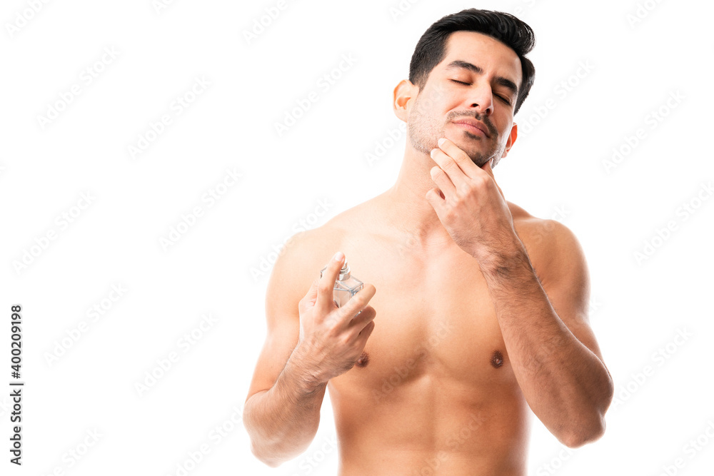 Fototapeta premium Young man putting on some cologne