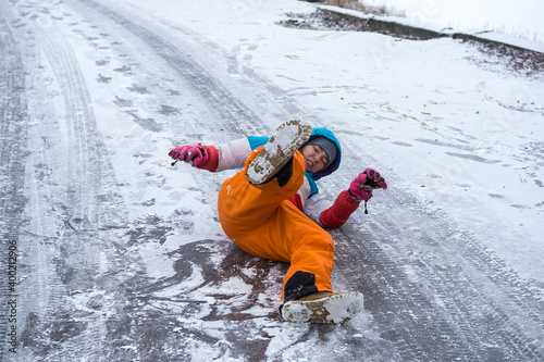 Woman is lying on a icy on road. Fall down because of slippery way. People can brake hand or leg.