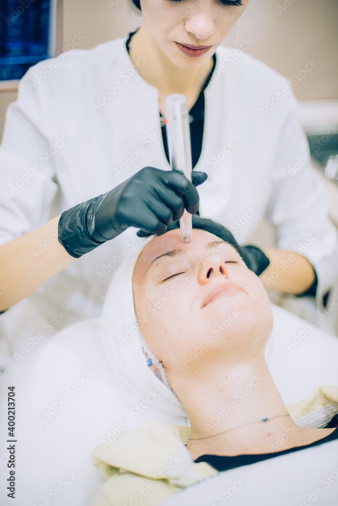 Naklejka premium young woman with problem skin receiving mesotherapy facial treatment in beauty clinic