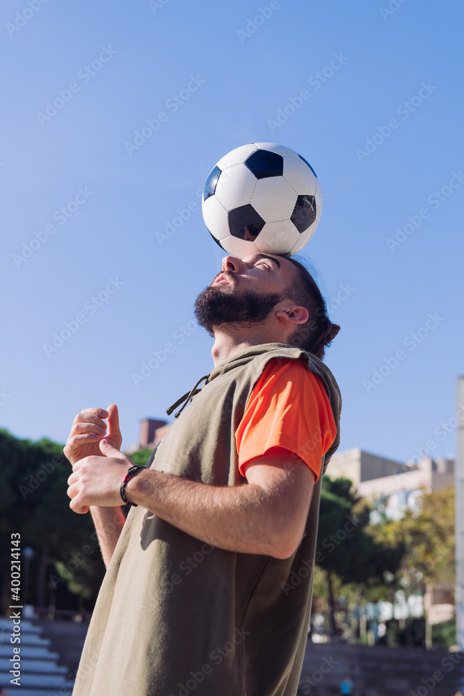 soccer player balancing the ball on his head