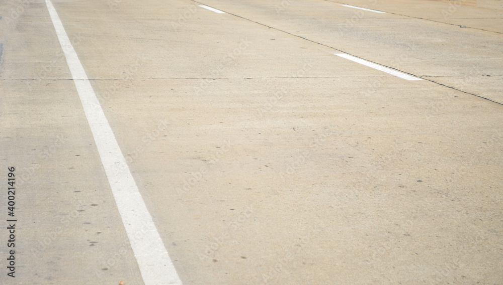 White traffic line on old concrete pavement road with longitudinal joint, construction joint,traffic lane line and traffic island.Empty concrete road.