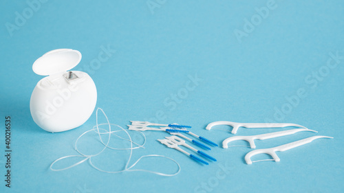 Home dental care kit. Different tools for dental care on blue background. Floss picks floss interdental brush. Top view