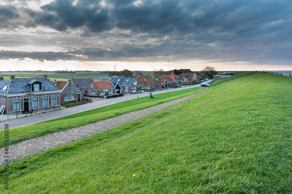 View of the Wadden Sea dyke and Moddergat, picturesque village in Friesland