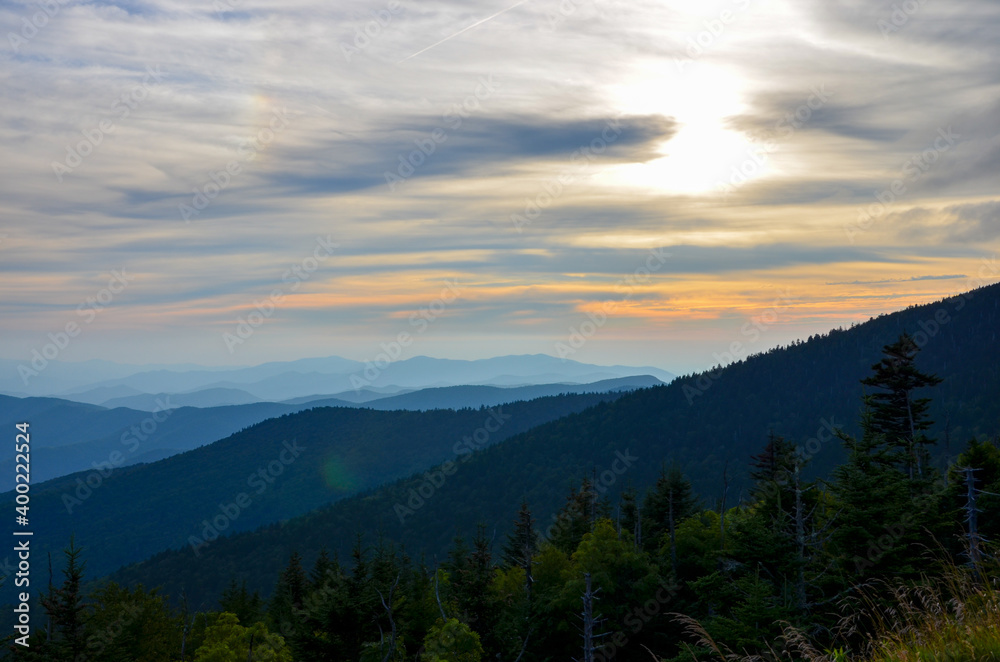 Great Smoky Mountains National Park in North Carolina at sunset, different high mountain ranges, orange evening sky background