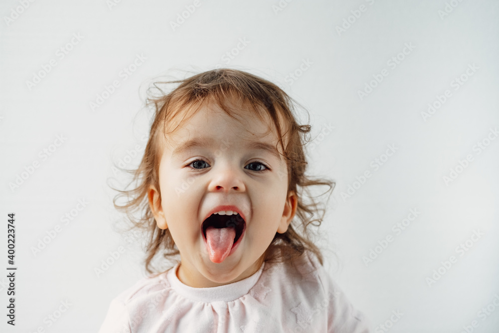 a child on a white background shows his tongue in his mouth, emotions. a child on a white background shows his tongue in his mouth, emotions.