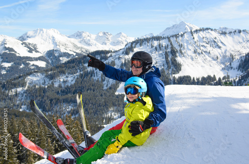 Smiling little boy with father in the mountains during ski holiday