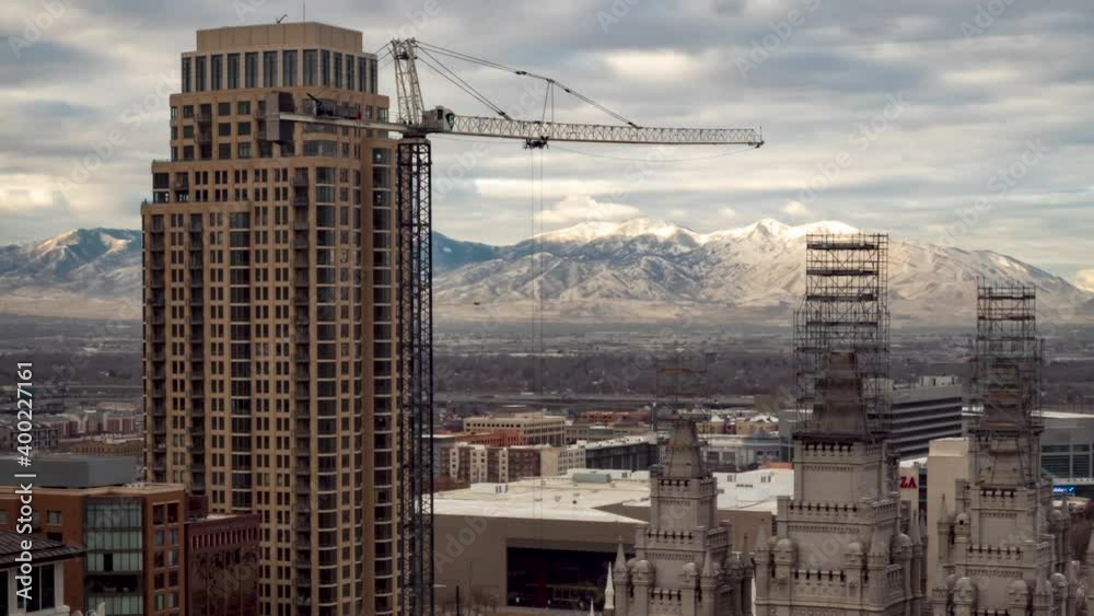 Downtown Salt Lake City, Utah time lapse with a crane moving in the foreground, the Mormon Temple and mountains and a cloudscape in the background Downtown Salt Lake City, Utah time lapse with a crane moving in the foreground, the Mormon Temple and mountains and a cloudscape in the background