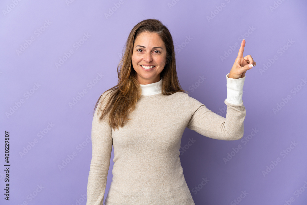 Middle age Brazilian woman isolated on purple background pointing up a great idea Middle age Brazilian woman isolated on purple background pointing up a great idea