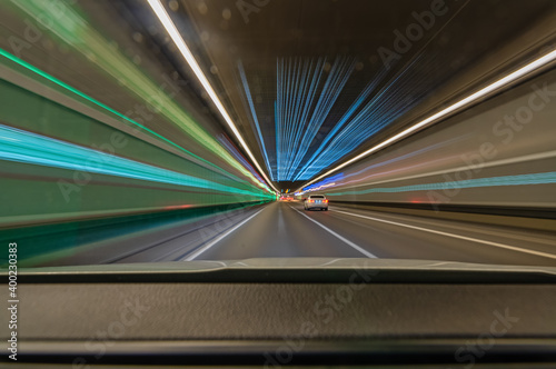 Speed driving car with light trails in a tunnel, fast accelerated highspeed photo.