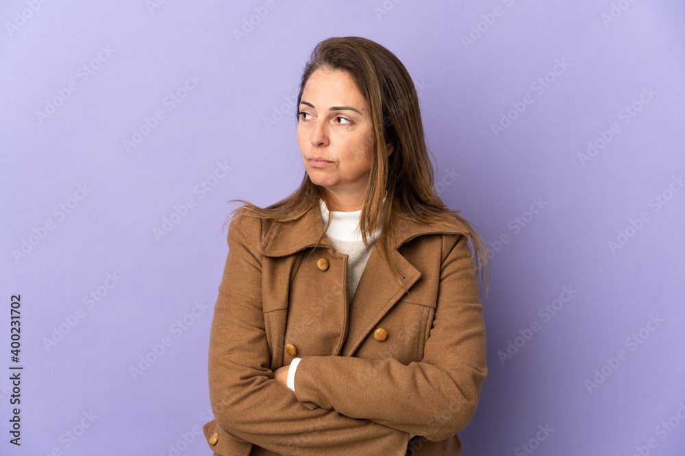 Middle age Brazilian woman isolated on purple background keeping the arms crossed Middle age Brazilian woman isolated on purple background keeping the arms crossed