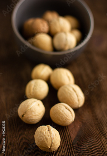 beautiful whole walnuts in a gray bowl on a wooden table