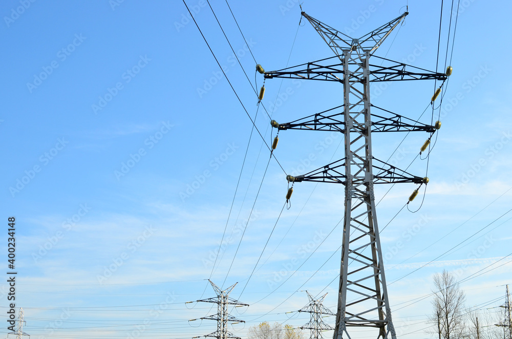 High voltage power lines on blue sky background. Electric transmission pylon tower. Wire electrical energy. Electricity concept