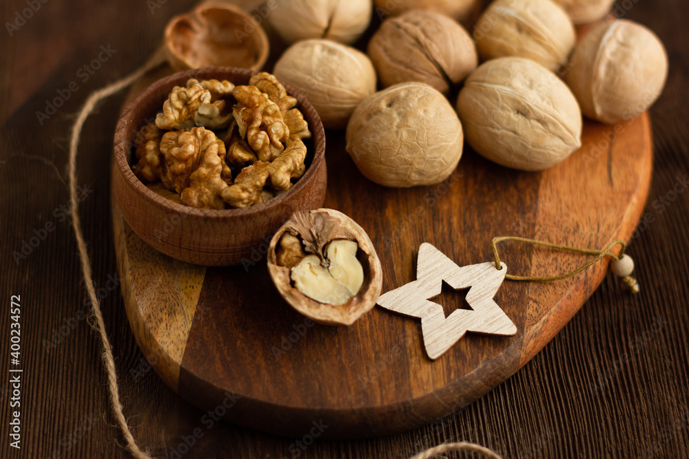 many whole walnuts on a board next to chopped walnuts and walnut kernels on a wooden background