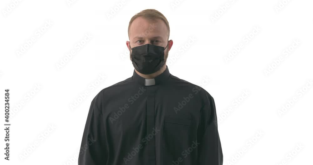 Shot of resolute caucasian priest in face mask showing crossed arms in X-gesture. Stop prohibit gesture. Isolated on white background Shot of resolute caucasian priest in face mask showing crossed arms in X-gesture. Stop prohibit gesture. Isolated on white background