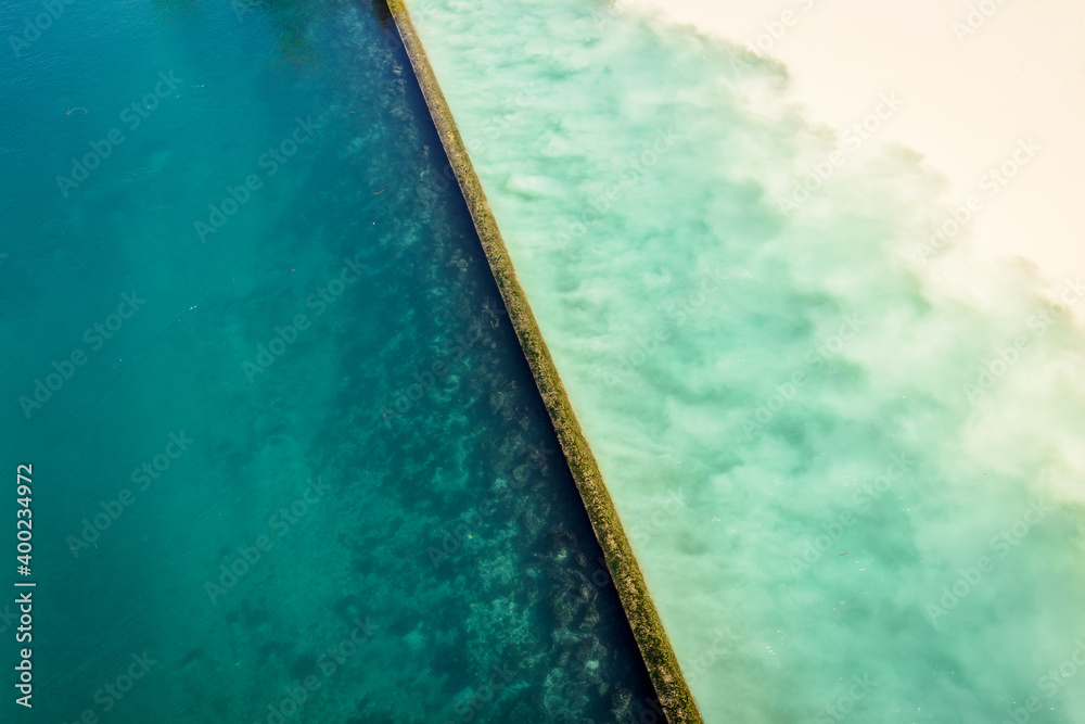 High angle view of the emerald blue waters of the Rhone river and the yellowish silty waters of the Arve river blending at their confluence called the Junction in Geneva, Switzerland.