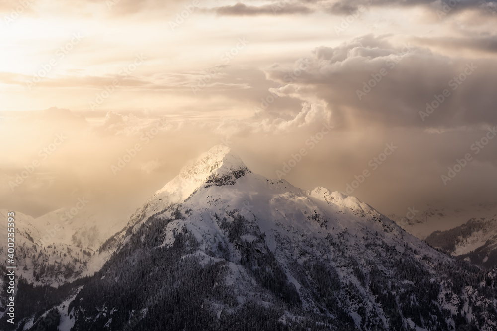 Beautiful aerial landscape view of Mountain Peaks near Vancouver, British Columbia, Canada. Dramatic Stormy Cloudy Sunset Sky Art Render.