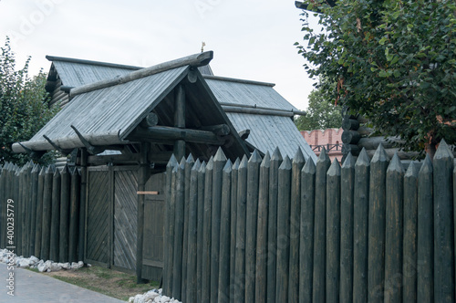 old wooden fence. reconstruction of a medieval settlement. fence and gate made of logs. tourist places and walks.