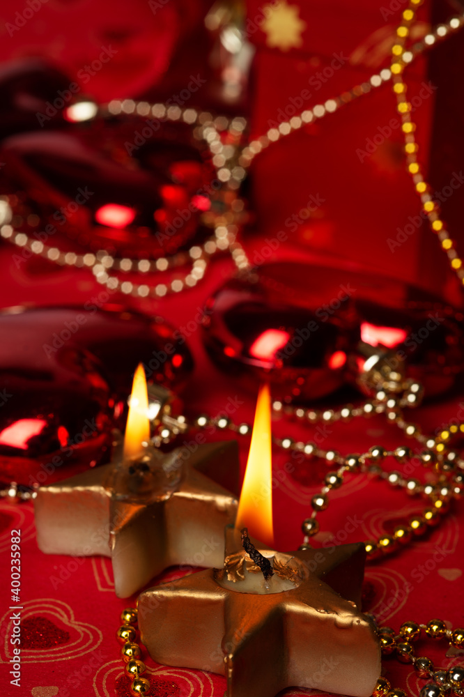 Christmas burning candles with decorations and  presents  at red background. Christmas holiday concept