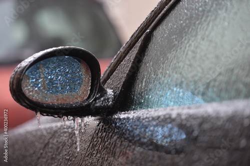 Car mirror covered by icy rain/ freezing rain/ frozen car.